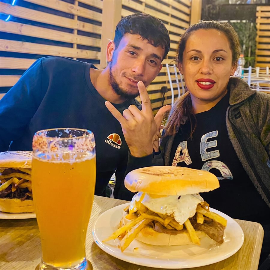 Clientes felices compartiendo hamburguesas y cerveza en Koko Shop