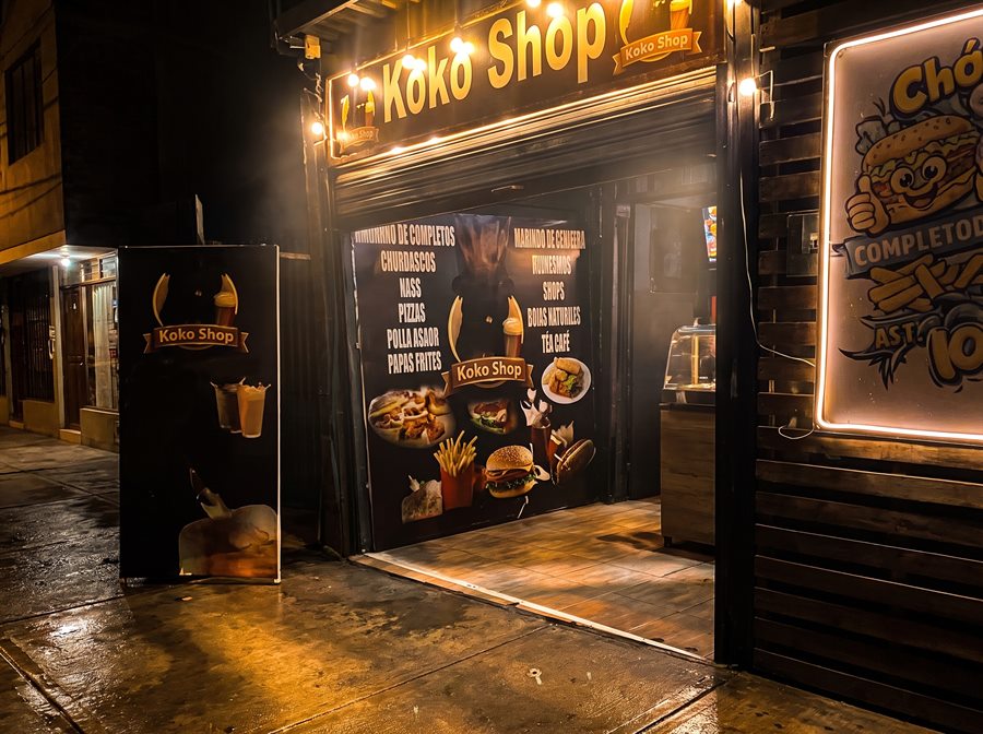 Frontis nocturno de Koko Shop con su letrero iluminado